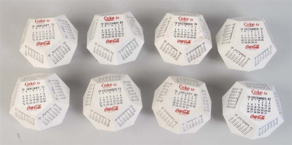 LOT OF 8: WEIGHTED COCA-COLA CALENDARS.           