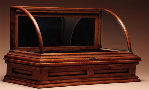 OAK BOW FRONT DISPLAY CASE WITH DRAWER.           