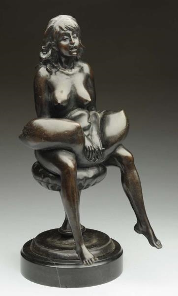 NUDE BRONZE SITTING ON STOOL WITH PILLOW.         