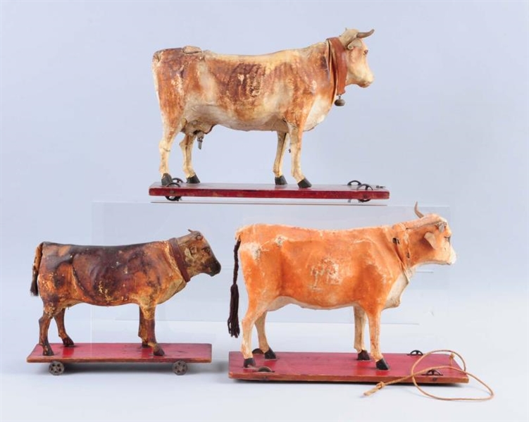 LOT OF 3: COWS ON WHEELED BASES.                  