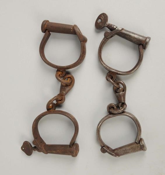 LOT OF 2: PAIRS OF ANTIQUE HANDCUFFS.             