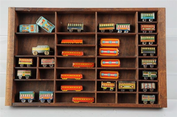 30 TIN LITHO SMALL TOY TRAINS WOODEN DISPLAY.     
