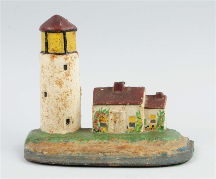 CAST IRON LIGHTHOUSE WITH COTTAGE DOORSTOP.       