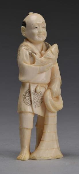 JAPANESE CARVED IVORY MAN WITH FISH.              