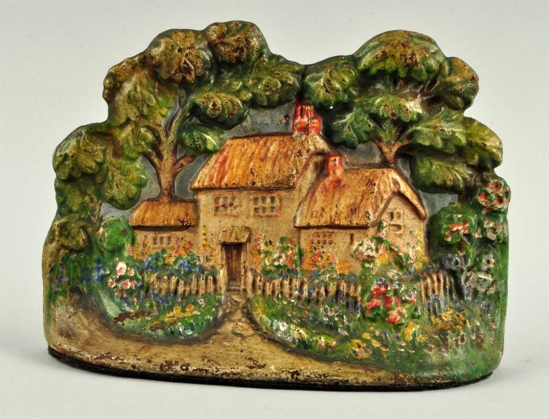 CAST IRON COTTAGE W/ THATCHED ROOF DOORSTOP.      