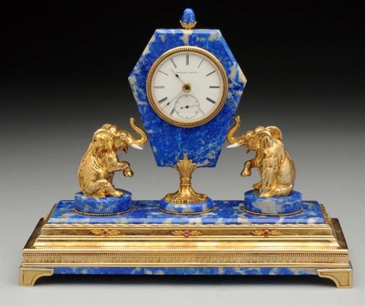 A SILVER GILT MOUNTED HARDSTONE CLOCK.            