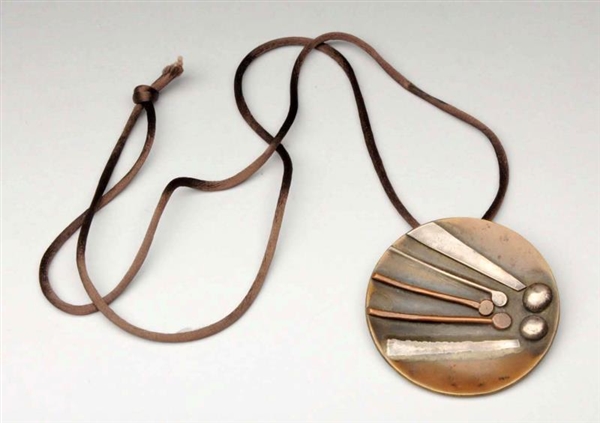 BRONZE ROUND PENDANT ON A NECKLACE.               