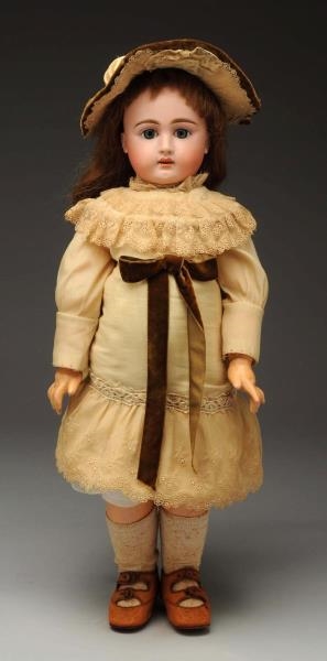 BISQUE DOLL IN HAT AND LACE DRESS.                