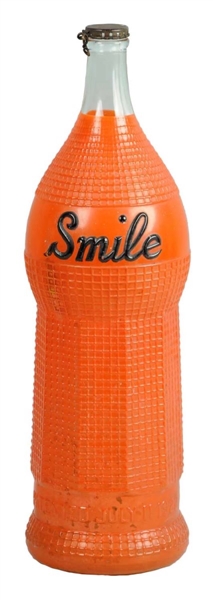 1920’S OVERSIZED ORANGE SMILE SODA DISPLAY BOTTLE.