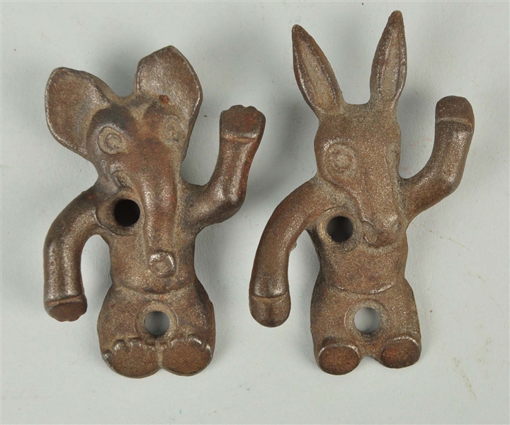 LOT OF 2: CAST IRON POLITICAL ASSORTED WALL MOUNT HOOKS.