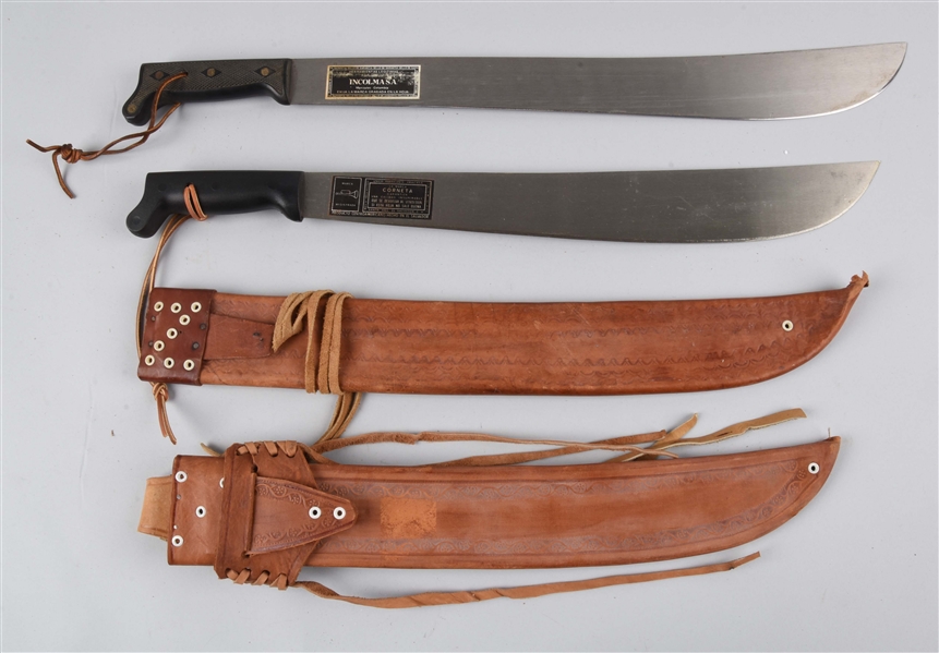 LOT OF 2: MACHETES IN LEATHER SHEATHS.