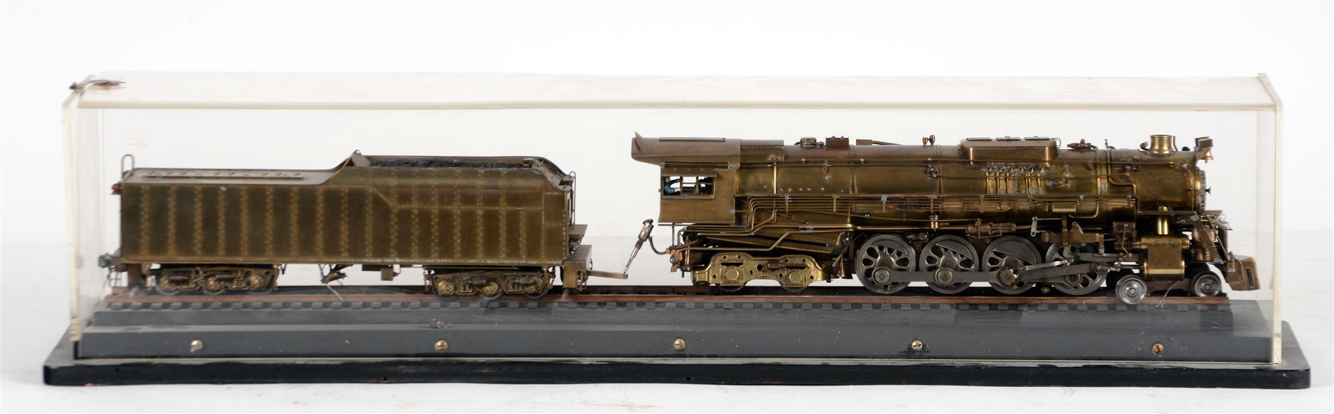 LOCOMOTIVE WITH TENDER ON TRACK IN DISPLAY CASE.
