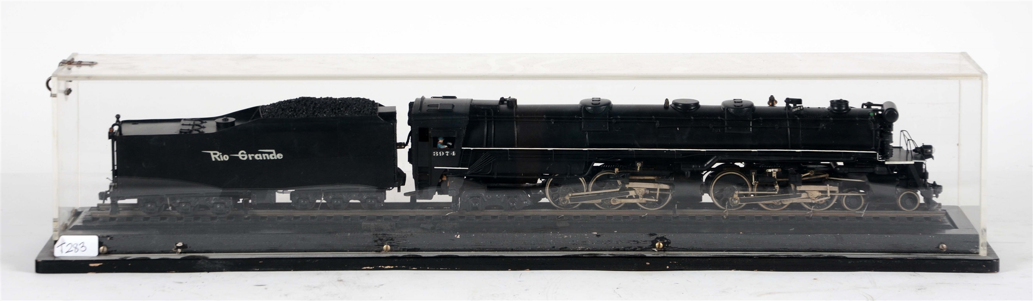 BRASS MODEL OF A RIO GRANDE STEAM LOCOMOTIVE AND TENDER IN DISPLAY CASE.
