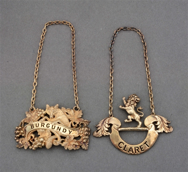 TWO BOXED ENGLISH SILVER-GILT WINE LABELS.