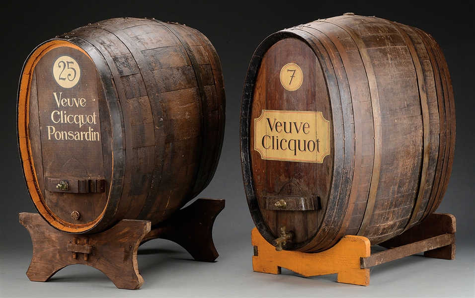 TWO LARGE VEUVE CLICQUOT WINE CASKS ON STANDS.                                                                                                                                                          