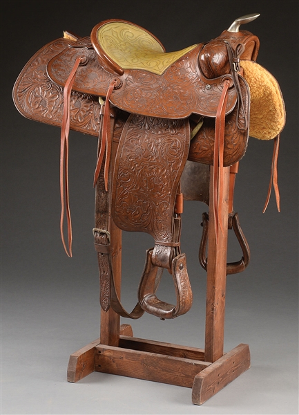 TOOLED WESTERN ROPING SADDLE MADE BY NUDIES RODEO TAILORS OF NORTH HOLLYWOOD, CALIFORNIA, ESPECIALLY FOR JOHN WAYNE.                                                                                   