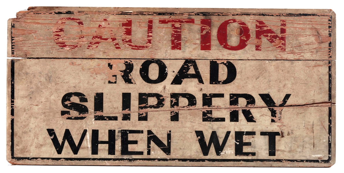 CAUTION ROAD SLIPPERY WHEN WET WOODEN ROAD SIGN.