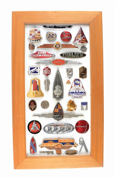COLLECTION OF 33 VARIOUS MOTOR CAR BADGES & EMBLEMS MOUNTED ON WOOD W/ FRAME. 