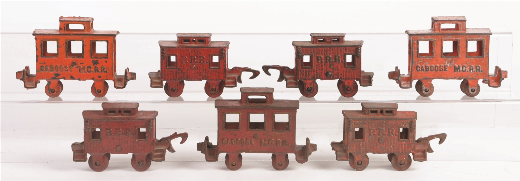 LOT OF 7: CAST-IRON FLOOR TOY CABOOSES BY EITHER HUBLEY OR DENT.