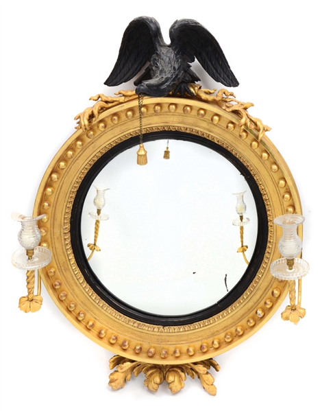 FINE CLASSICAL EBONIZED AND GILTWOOD DOUBLE-LIGHT CONVEX WALL MIRROR. FIRST QUARTER 19TH CENTURY.