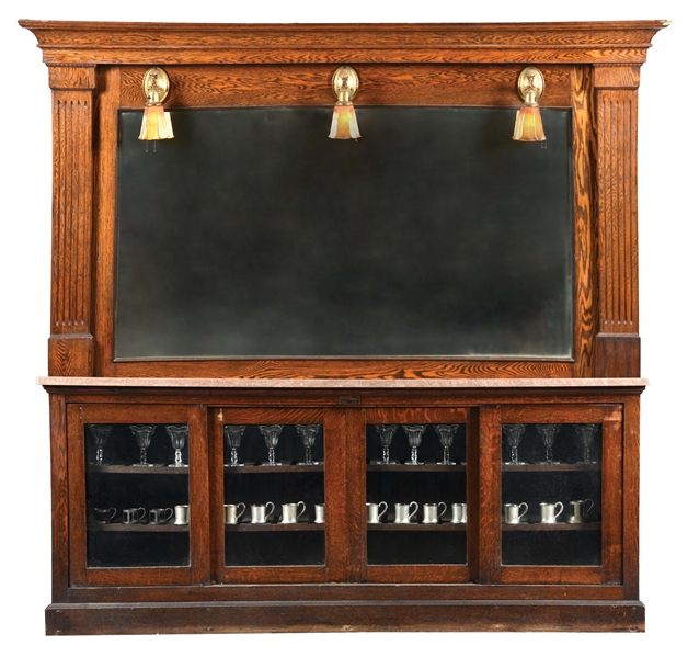 QUARTERED OAK BACK BAR WITH MARBLE TOP, MIRRORED BACK, AND GLASS FRONT STORAGE.