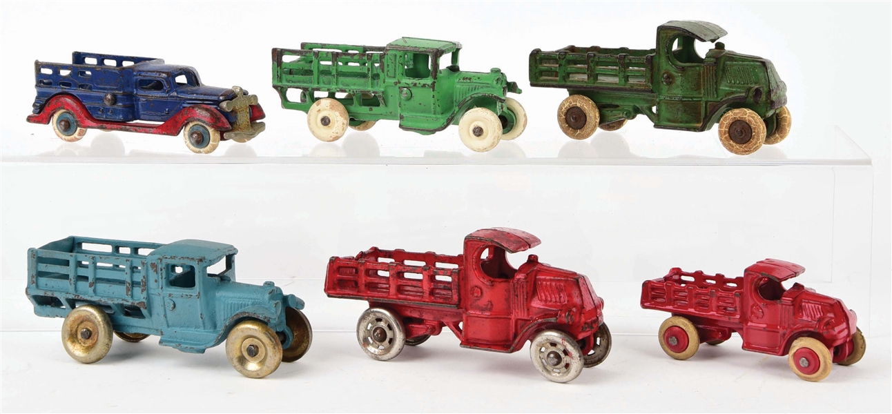 LOT OF 6: VARIOUS CAST-IRON AMERICAN MADE STAKE BACK TRUCKS.