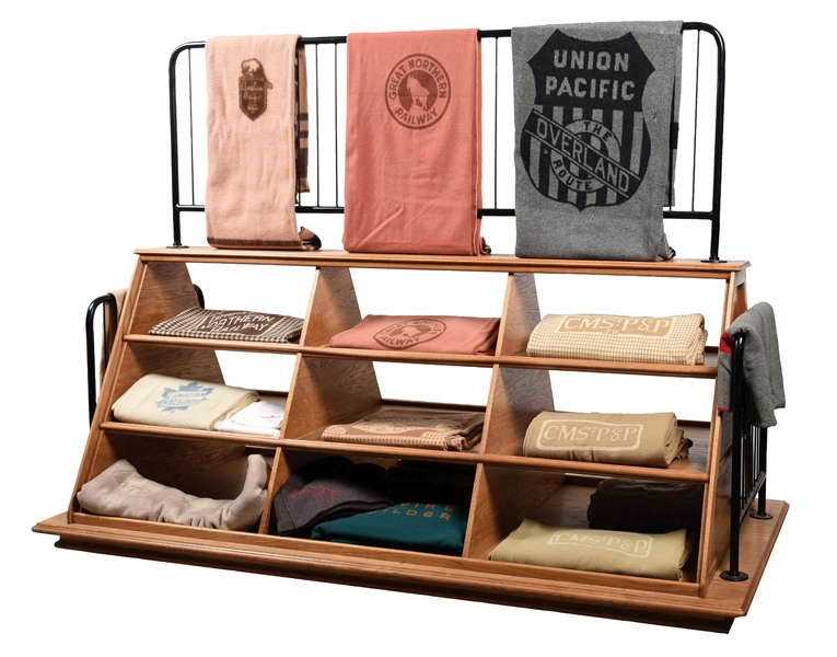CUSTOM MADE OAK TRAPEZOIDAL RAILROAD BLANKET DISPLAY STAND WITH 16 BLANKETS.