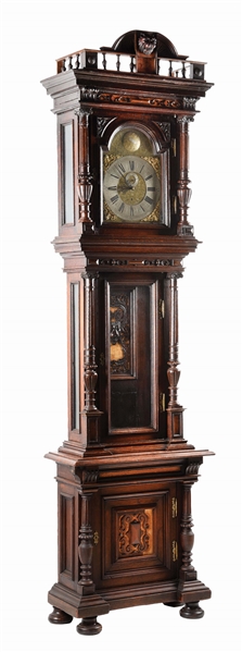 CARVED WALNUT TALL CASE CLOCK IN THE STYLE OF OTTO STEINER.