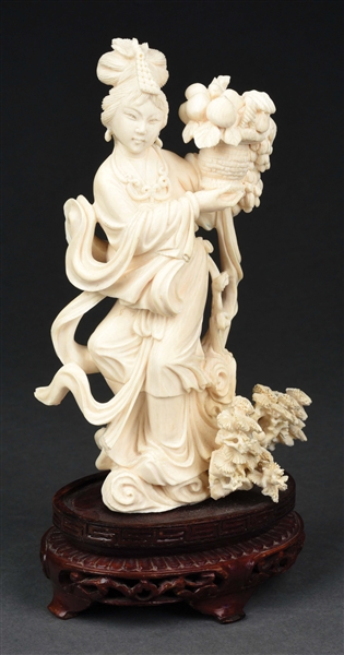 CARVED IVORY FIGURINE OF A WOMAN WITH FRUIT BASKET.