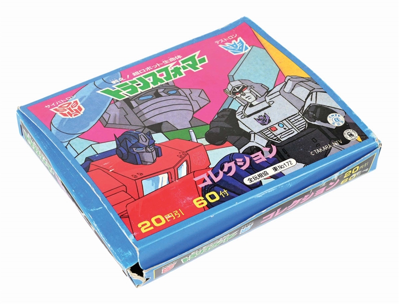 JAPANESE 1980S DECARA TRANSFORMERS STICKER BOX W/ OVER 50 PACKS OF STICKERS, SEVERAL ALBUMS & OTHER ITEMS